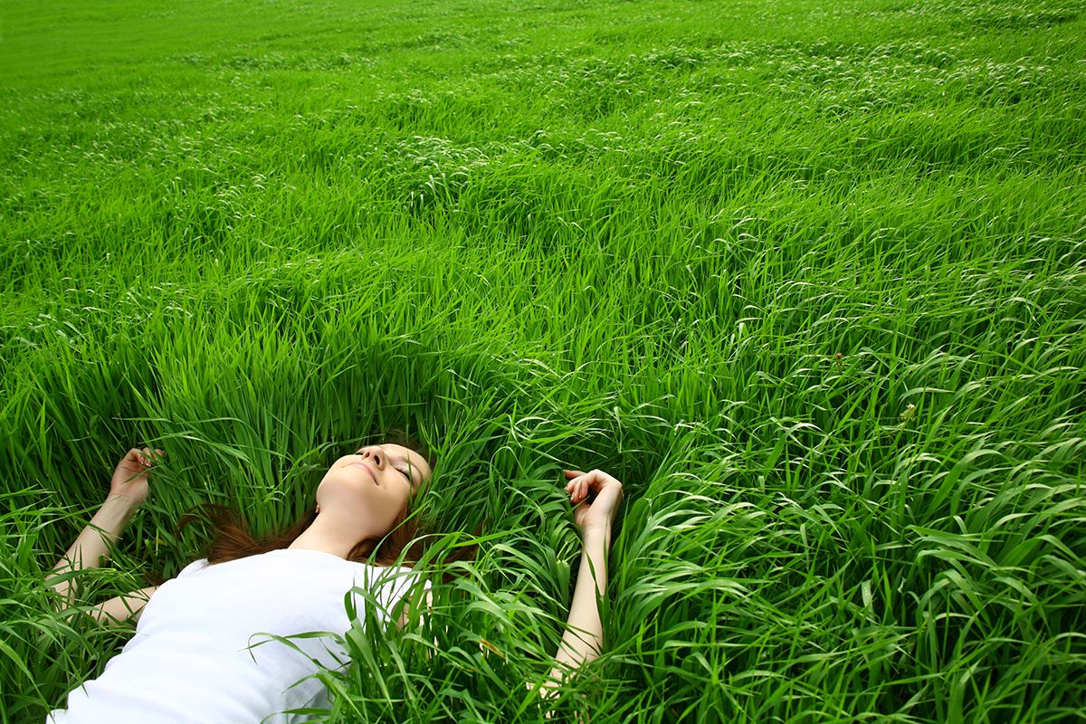 Woman lying relaxed in tall green grass